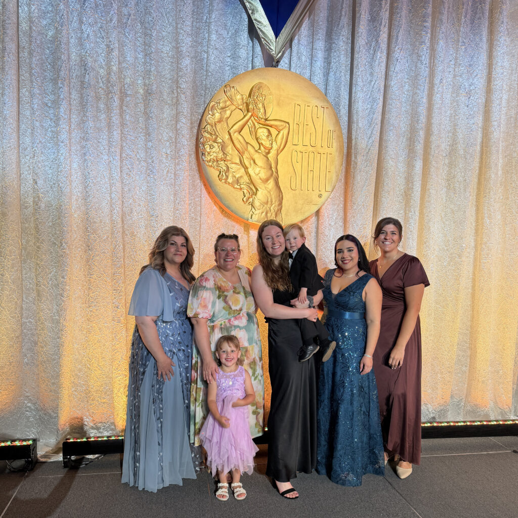 HOALiving Representatives take selfie take group photo in front of the large best of state award medal