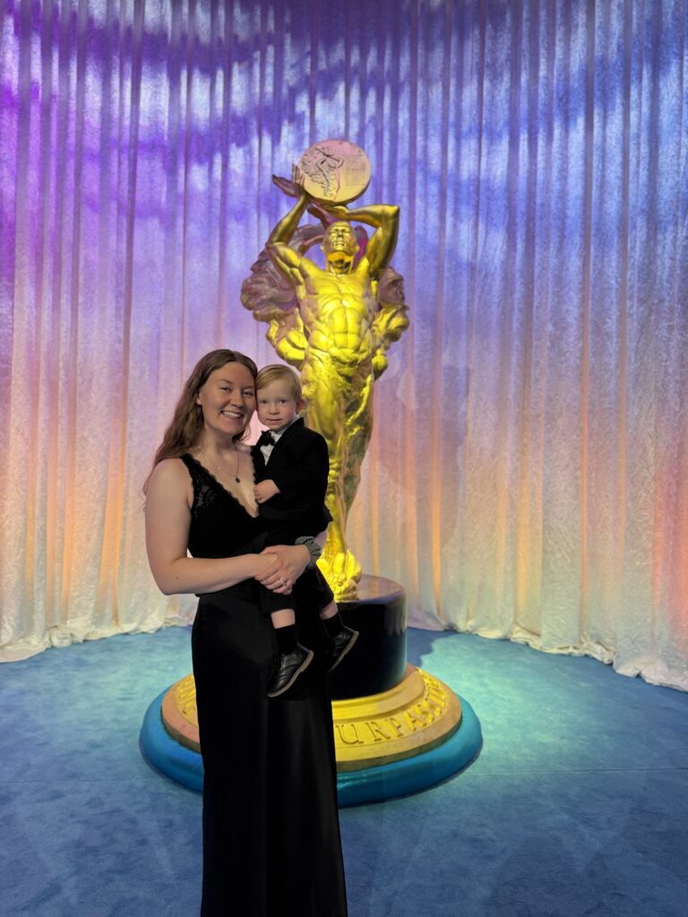 Rachel Iverson and son in front of Best of State award statue
