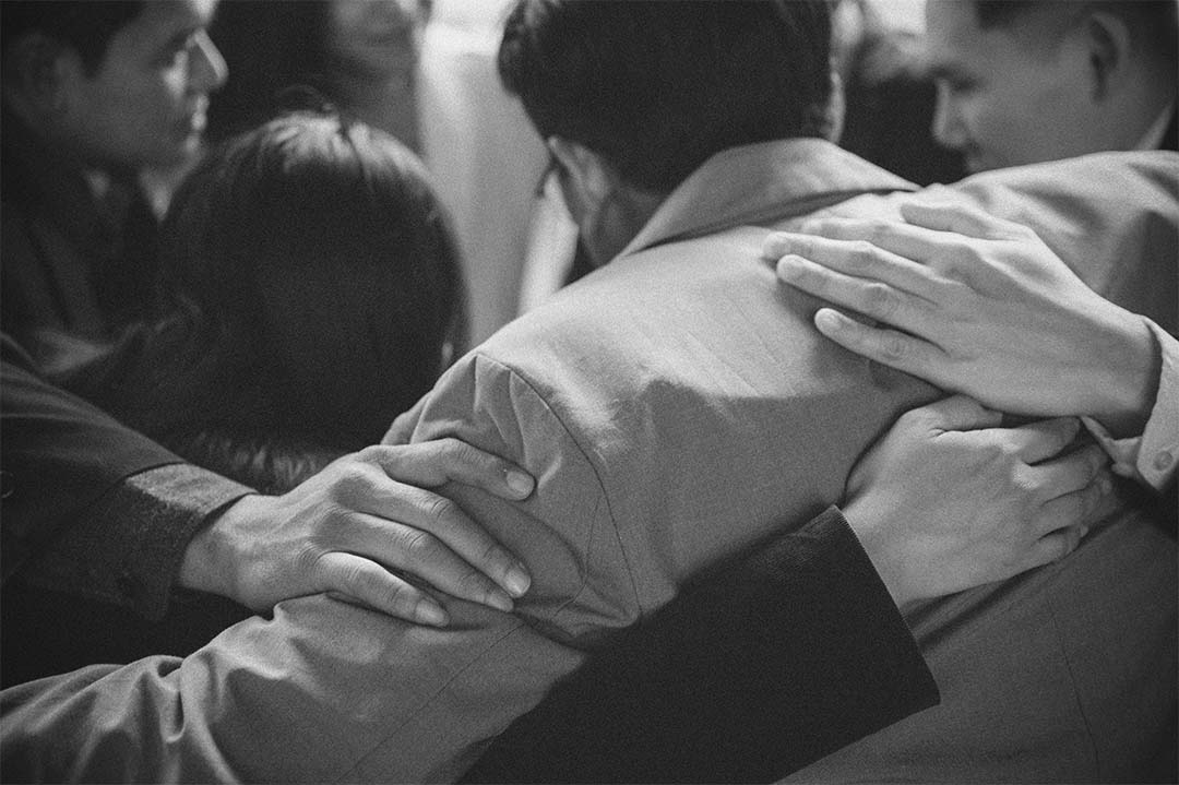 Business People Group standing hugging together in time of grief