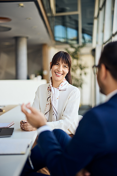Female Realtor engaging in professional conversation during a meeting with homebuyers in a contemporary office.
