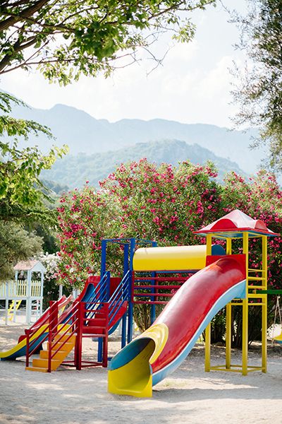 Children Playground in beautiful garden with mountains background