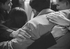 Business People Group standing hugging together in time of grief